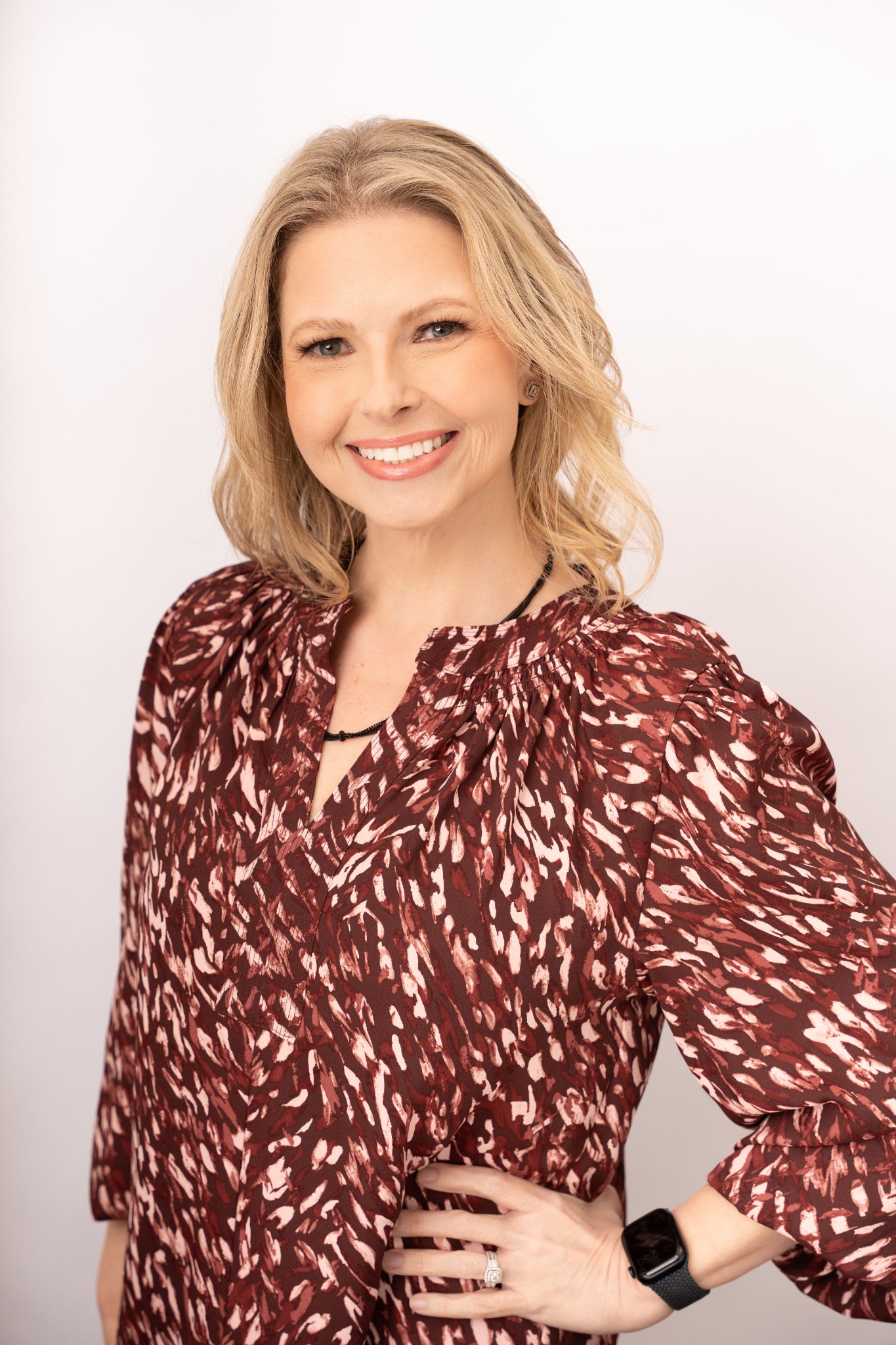 Crystal Rowell smiling in a burgundy patterned blouse